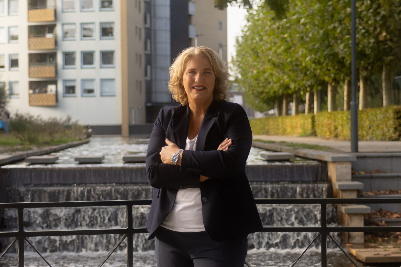 Makelaar met de armen over elkaar bij een waterpartij in de stad