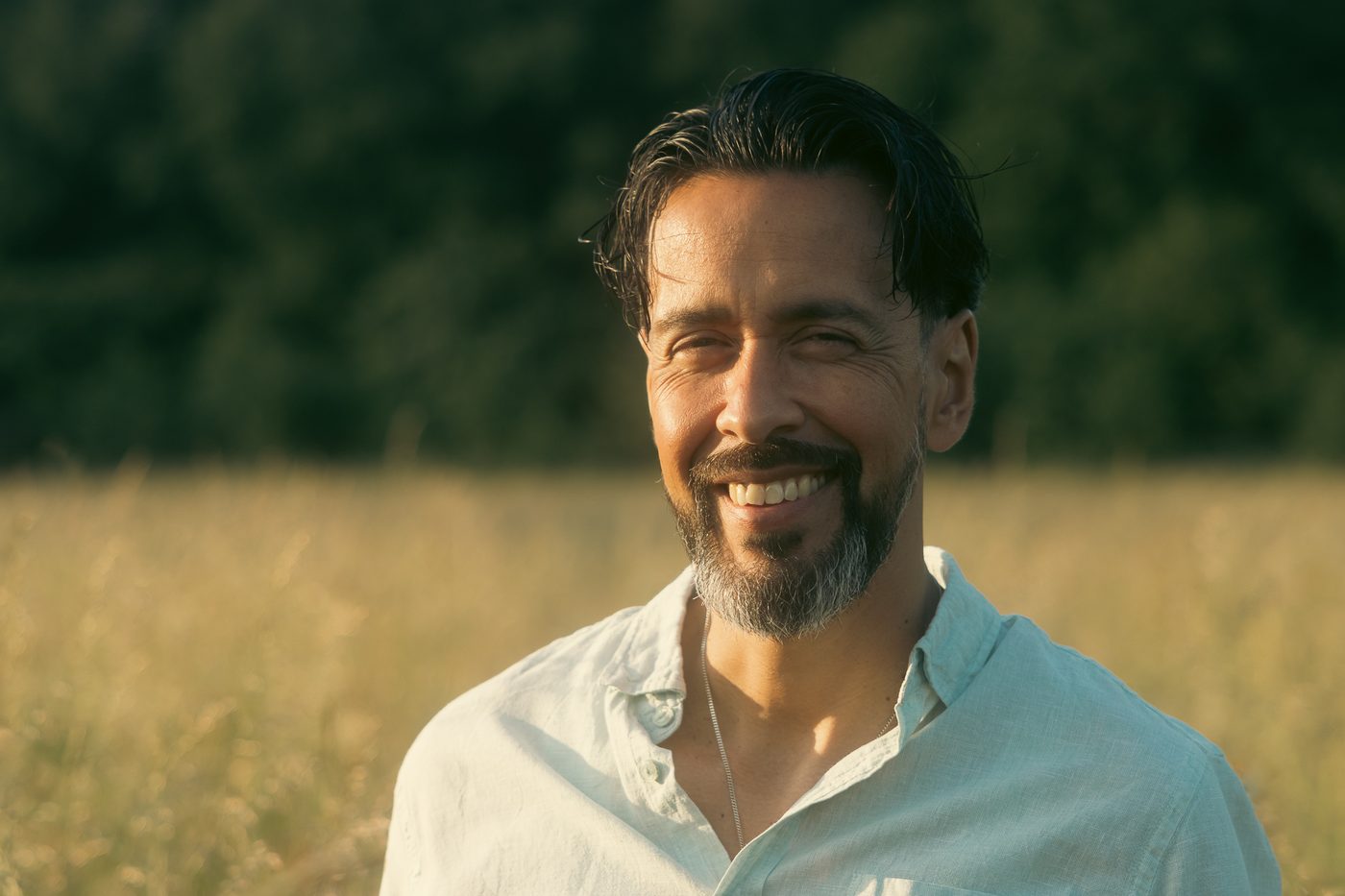 Lachende man in een zomers veld, achtergrond zacht onscherp